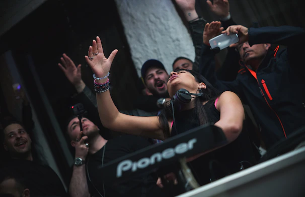 DJ Jusphyne engaging with the crowd, hands raised in celebration.