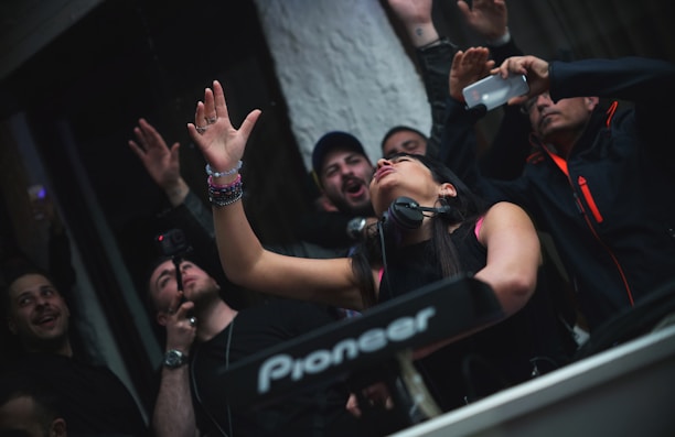 A DJ performing live at the Halloween event, surrounded by excited attendees.