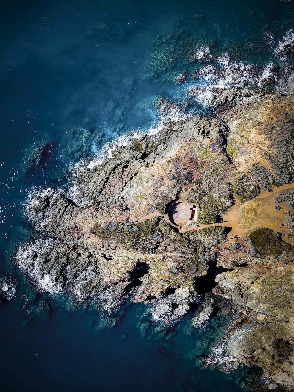 aerial view of green and brown mountain beside body of water during daytime