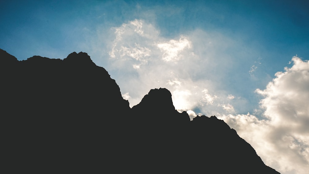 silhouette of mountain under blue sky during daytime