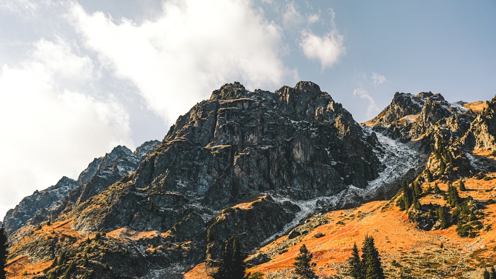 brown and gray rocky mountain under white cloudy sky during daytime