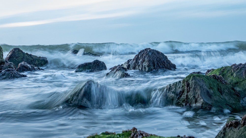 brown rock formation on body of water during daytime