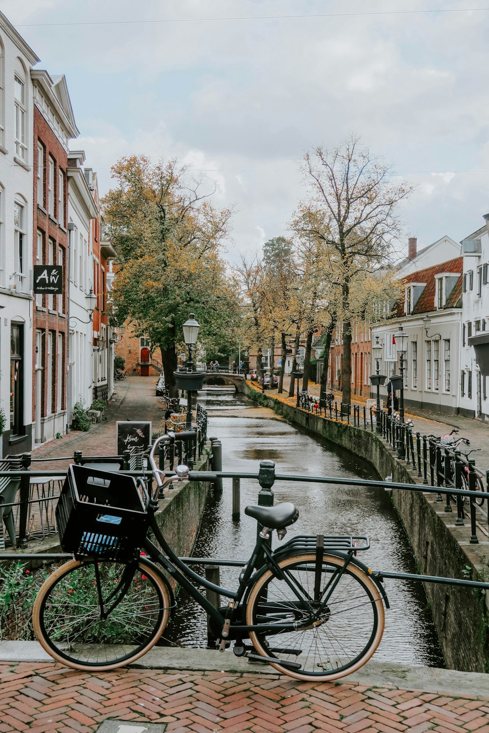 Vélo noir garé sur une clôture en métal gris près d’un bâtiment en béton brun pendant la journée