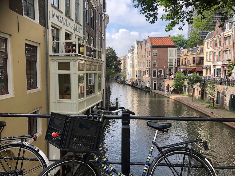 vélo de ville noir garé à côté d’une clôture en acier noir pendant la journée