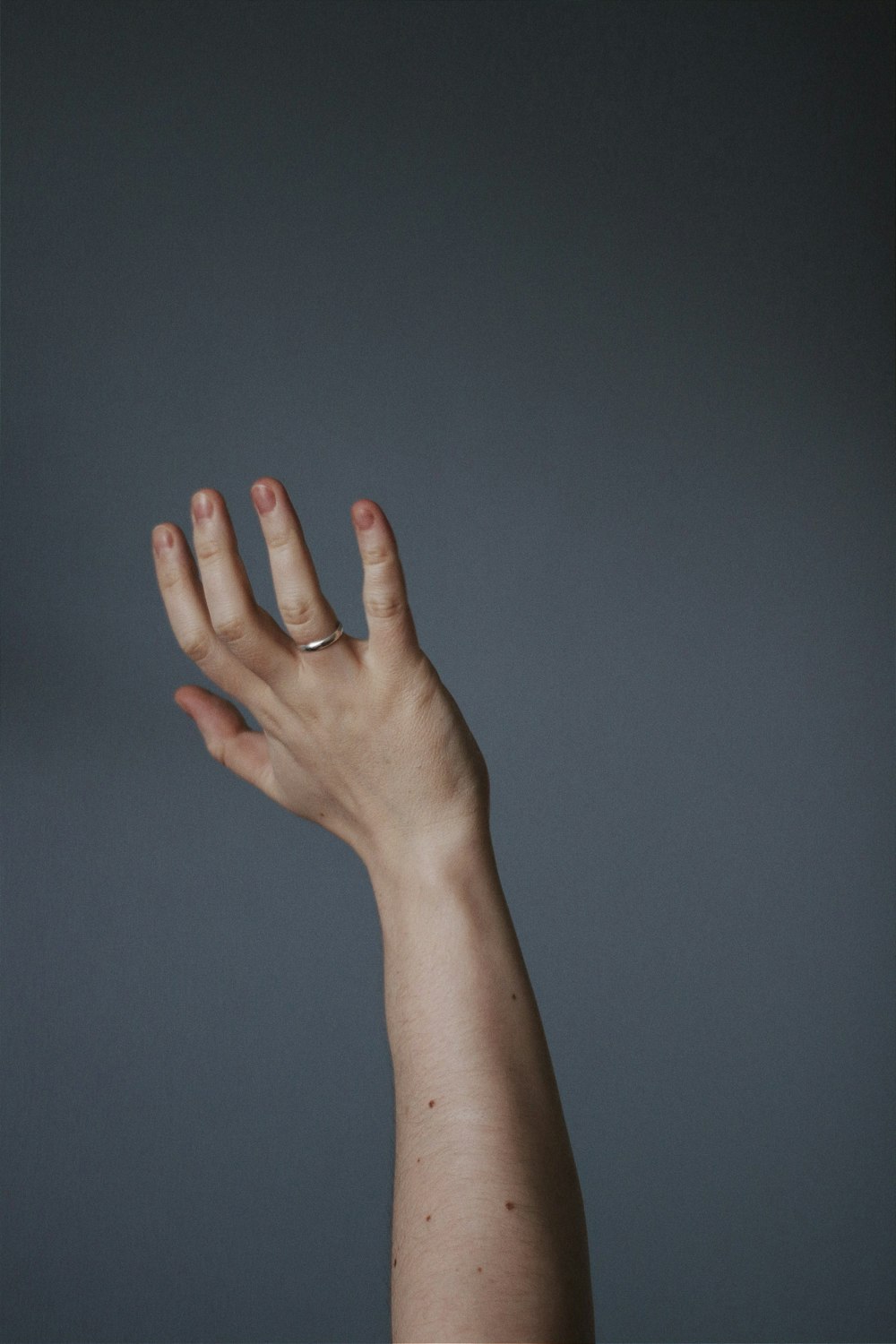 persons left hand on blue wall