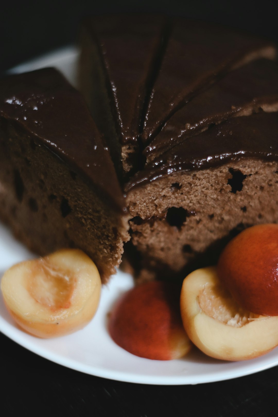 brown cake with sliced lemon on white ceramic plate