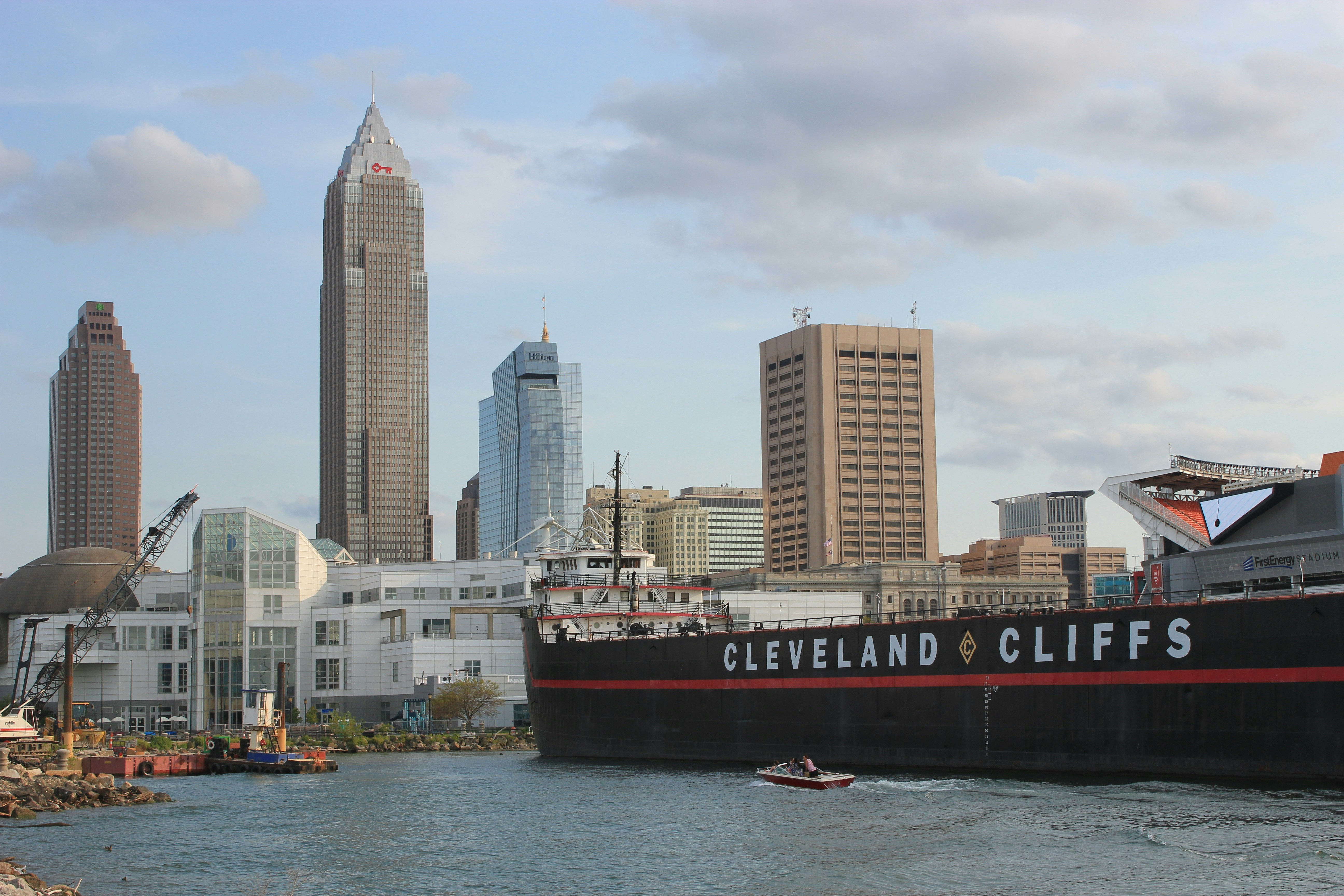 red and white ship on sea near city buildings during daytime