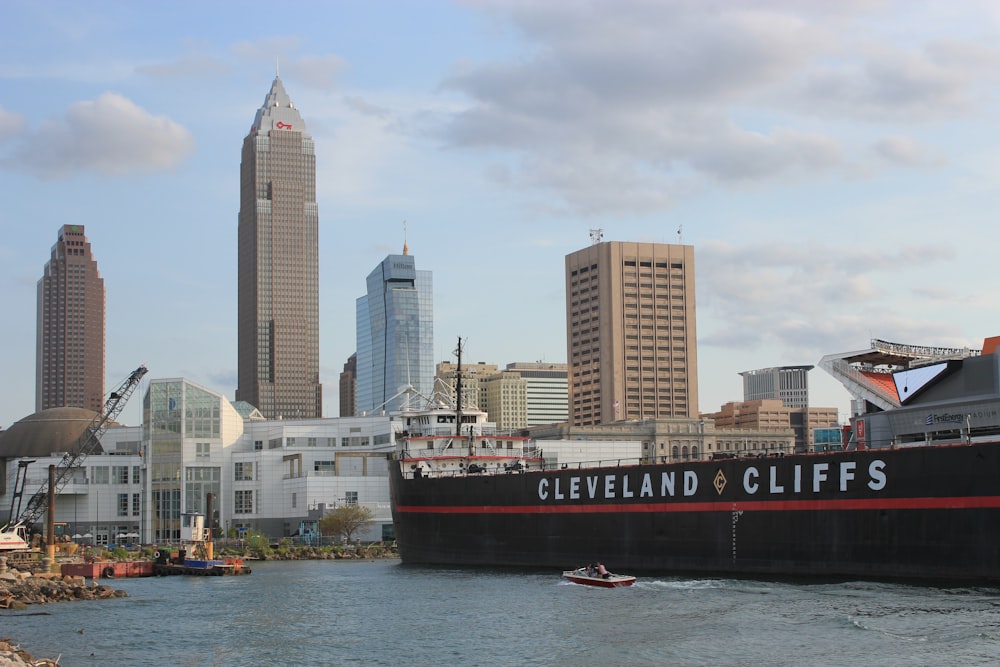 red and white ship on sea near city buildings during daytime