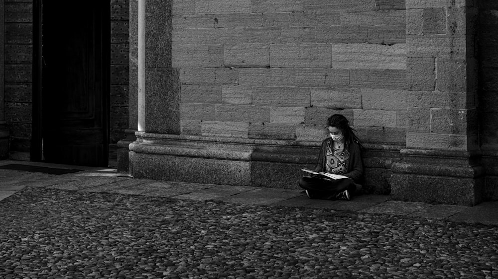 woman in black jacket sitting on concrete bench