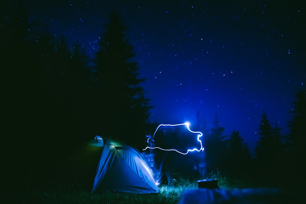 tenda bianca sotto il cielo blu durante la notte