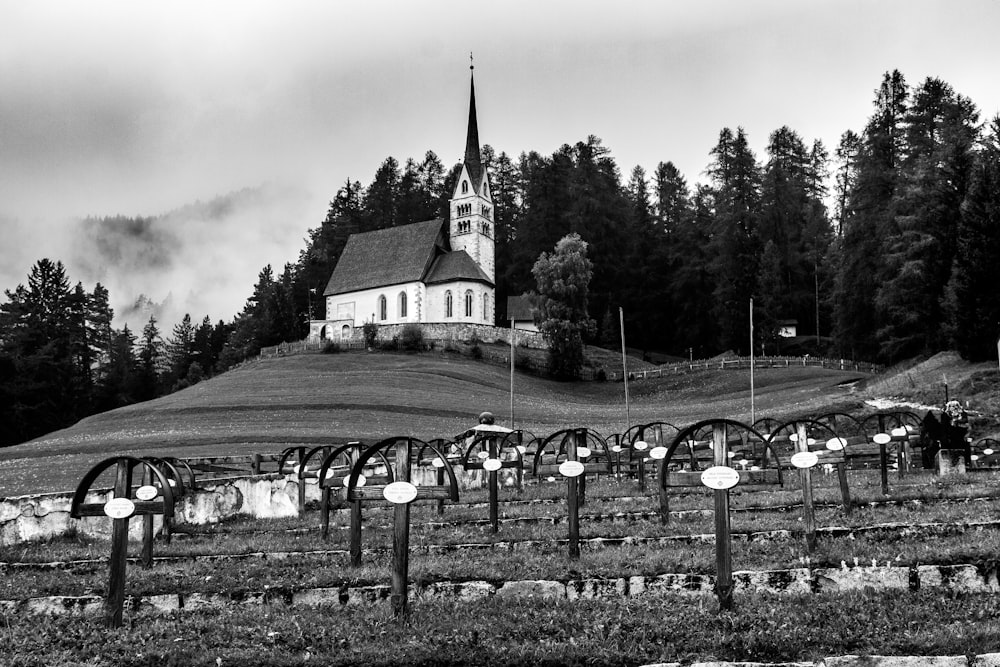 grayscale photo of church surrounded by trees