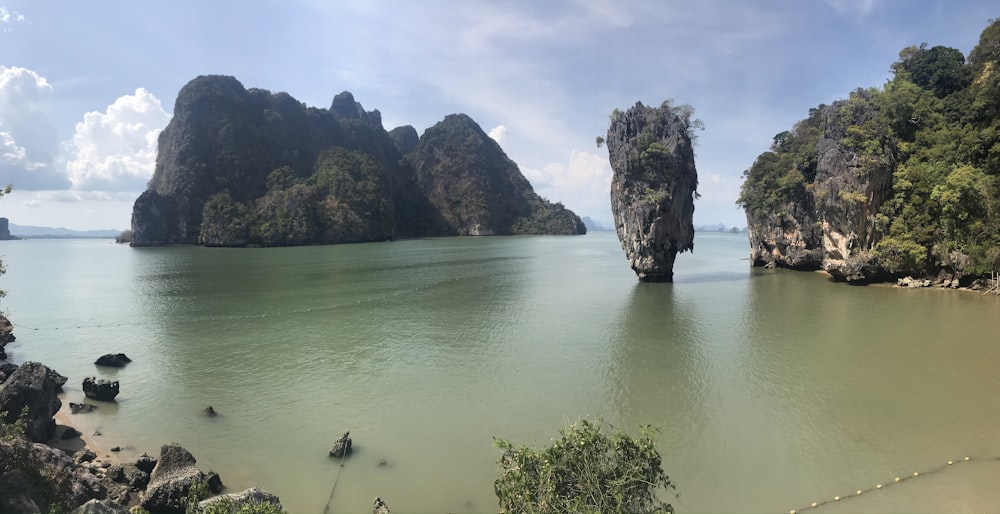 green body of water near brown rock formation during daytime