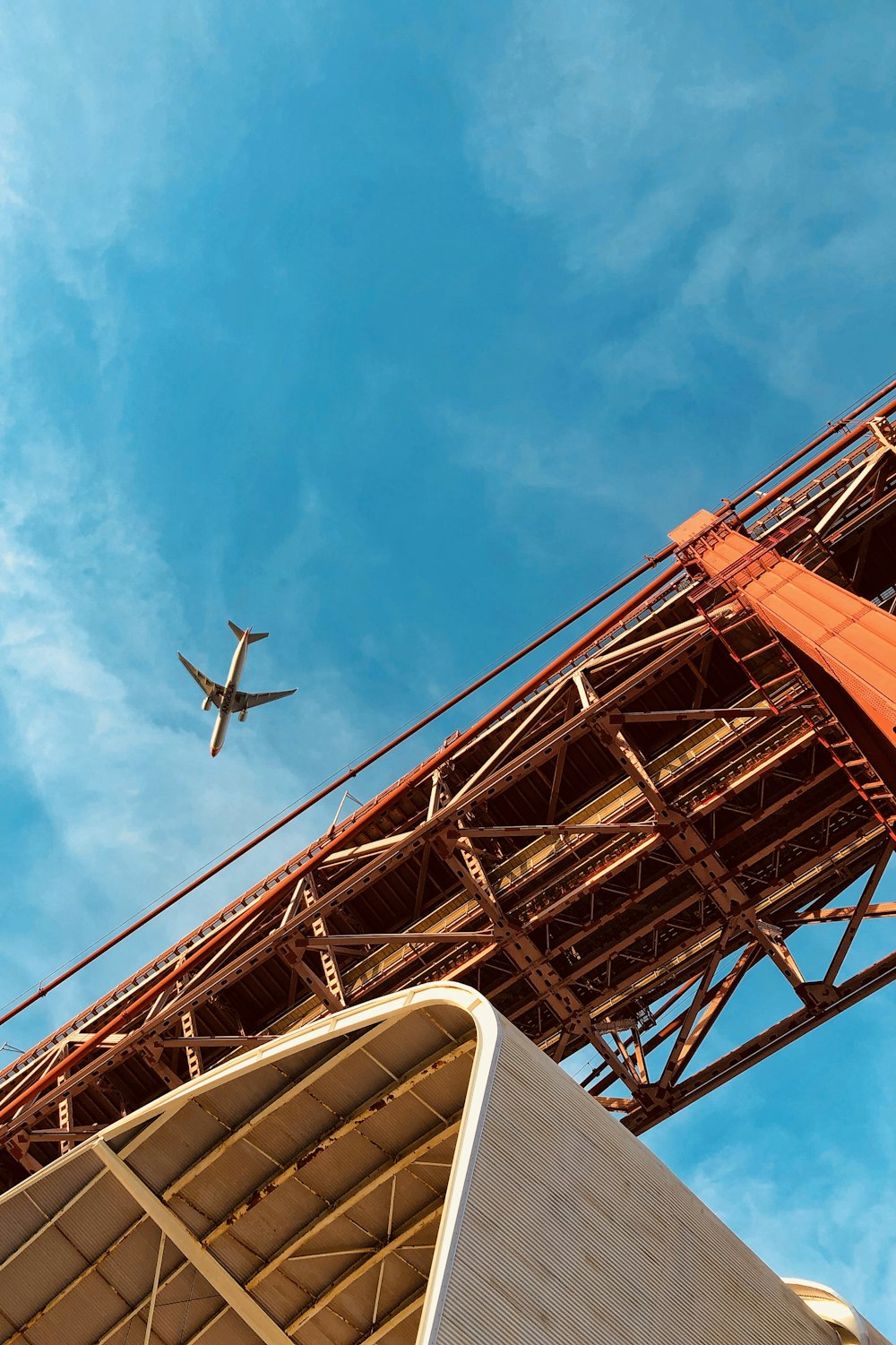 black airplane flying over the bridge during daytime