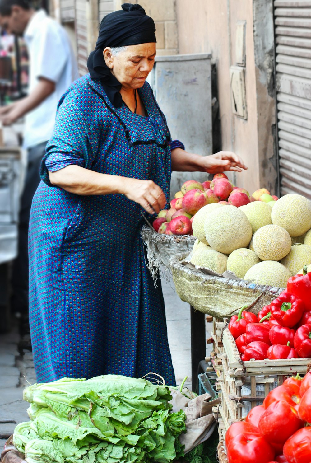 woman in blue dress holding basket of fruits