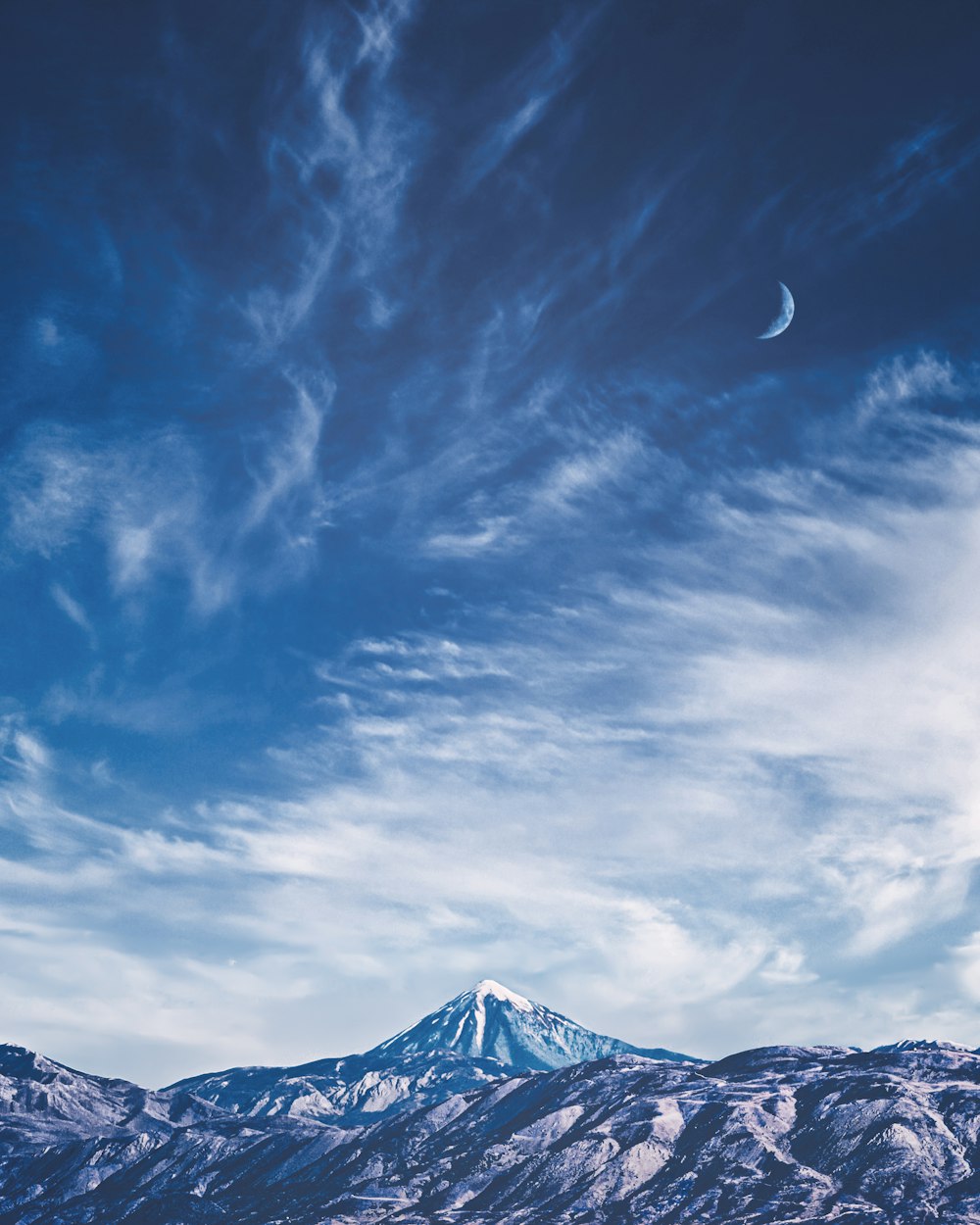Montagna sotto nuvole bianche e cielo blu durante il giorno