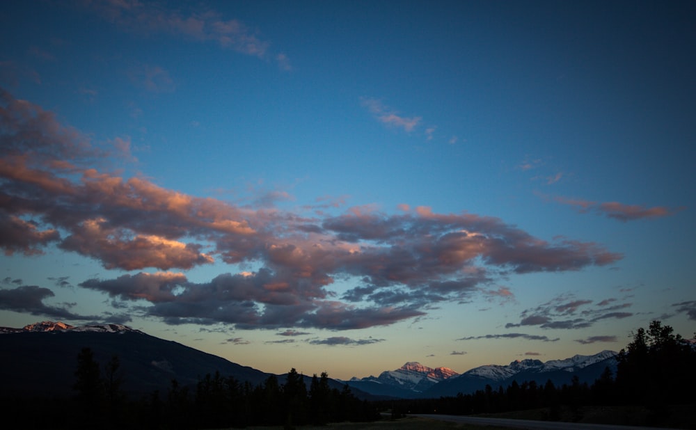 silhouette of mountain under cloudy sky during daytime