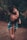 girl in black long sleeve shirt and blue skirt standing on brown soil during daytime