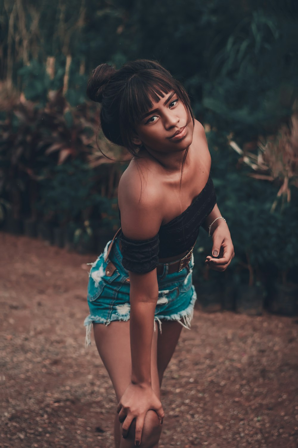 girl in black long sleeve shirt and blue skirt standing on brown soil during daytime