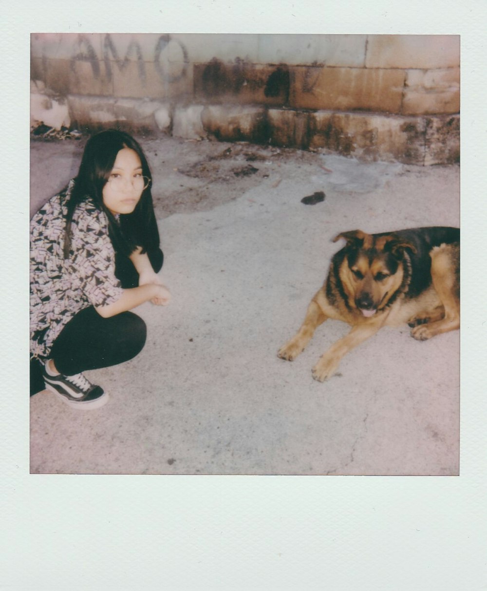 une femme agenouillée à côté d’un chien