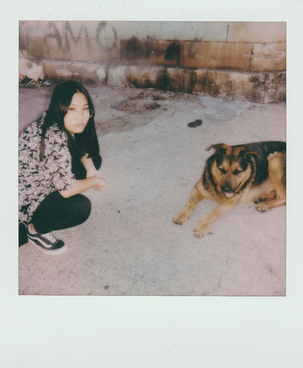 a woman kneeling down next to a dog