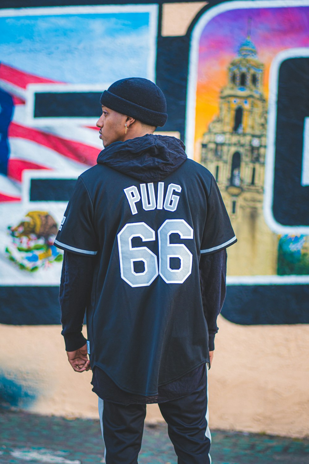 man in black and white adidas hoodie standing near wall