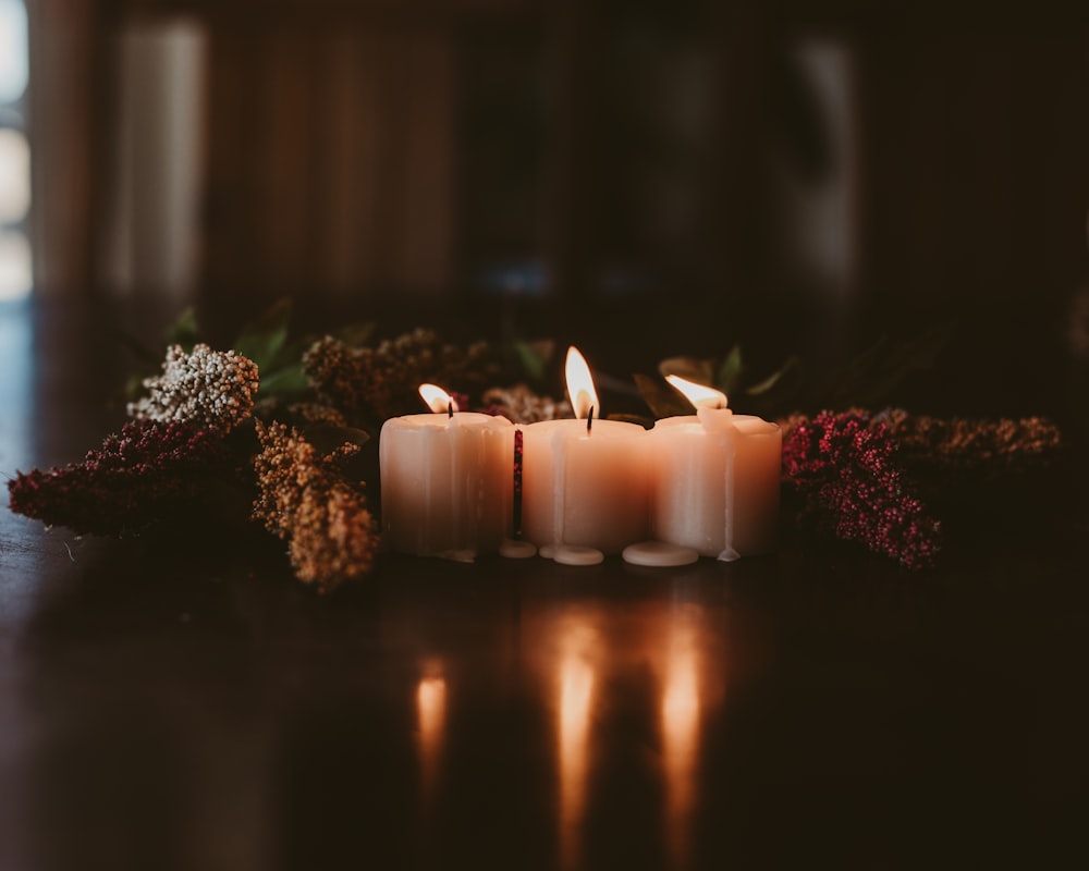 weiße Kerzen auf braunem Holztisch