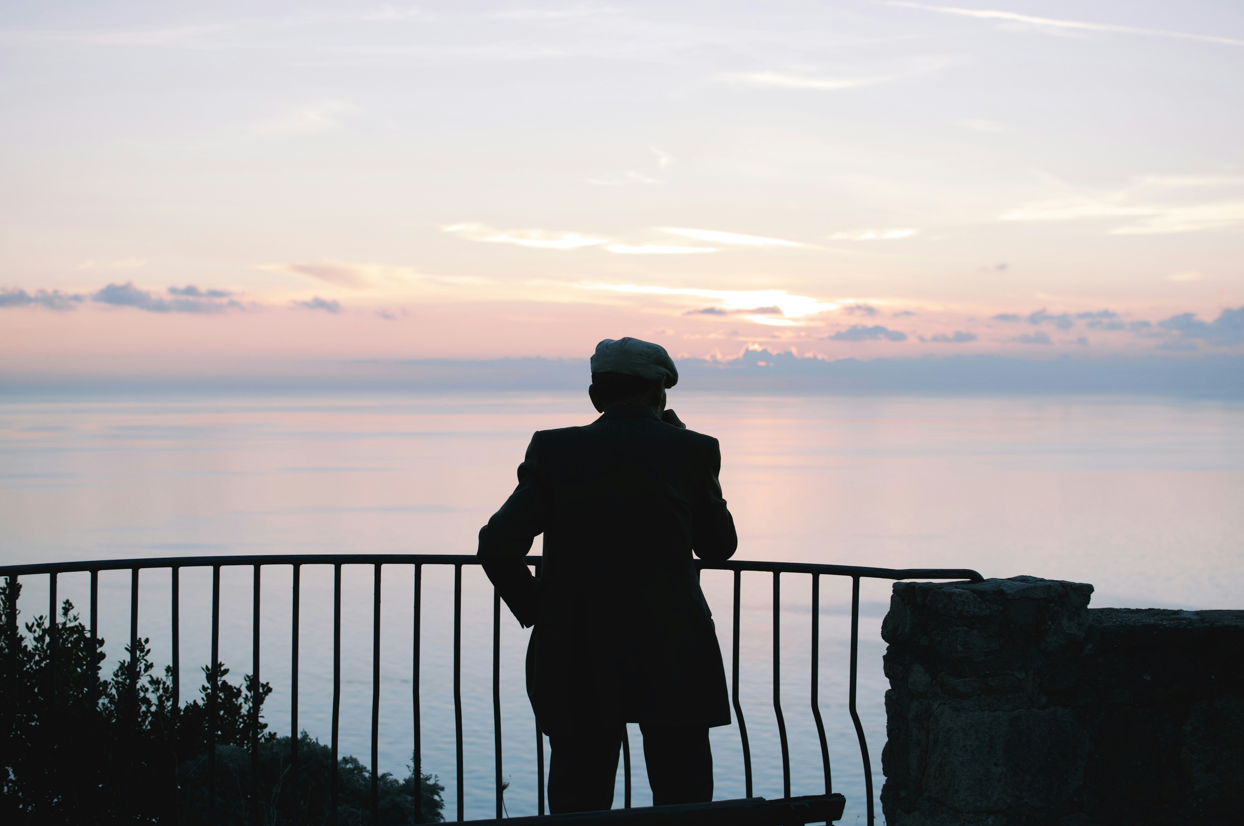 silhouette of man standing near railings during daytime