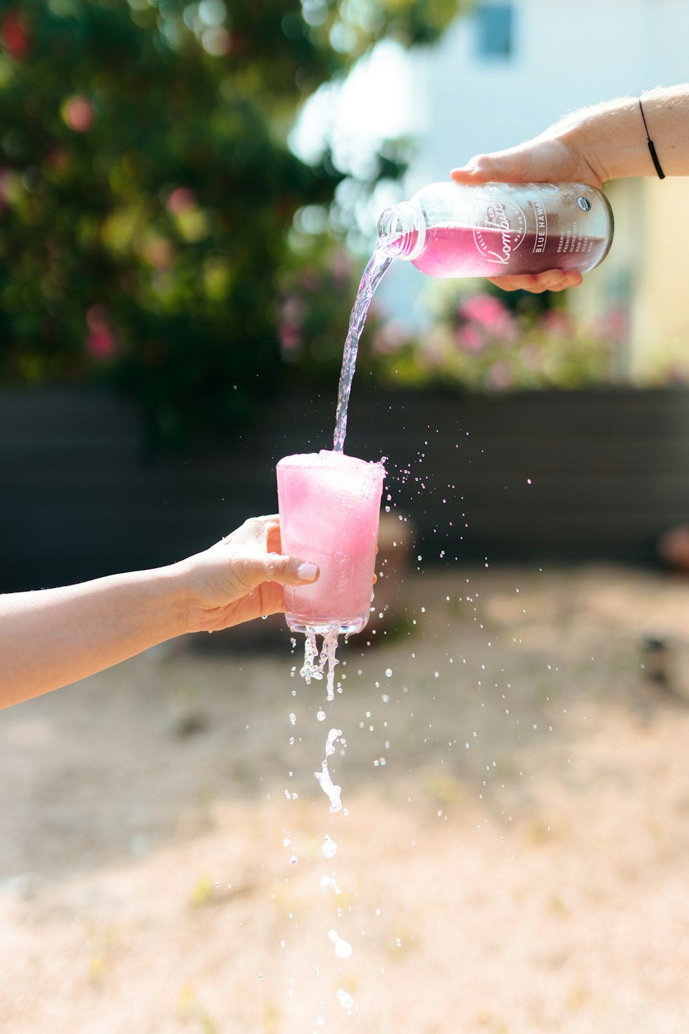 透明なプラスチックのコップに水を注ぐ人