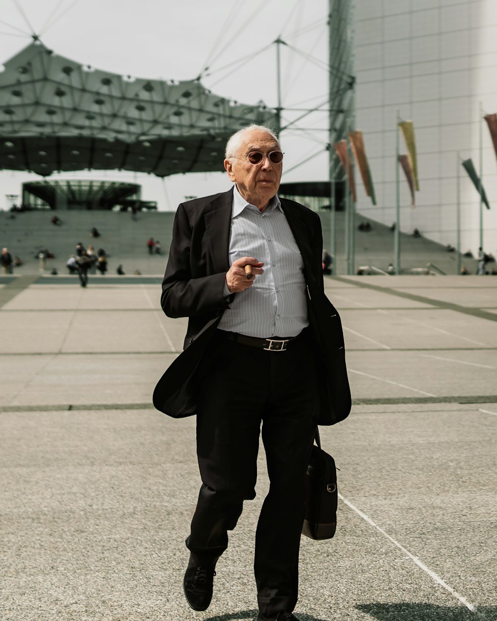 man in black suit standing on gray concrete floor