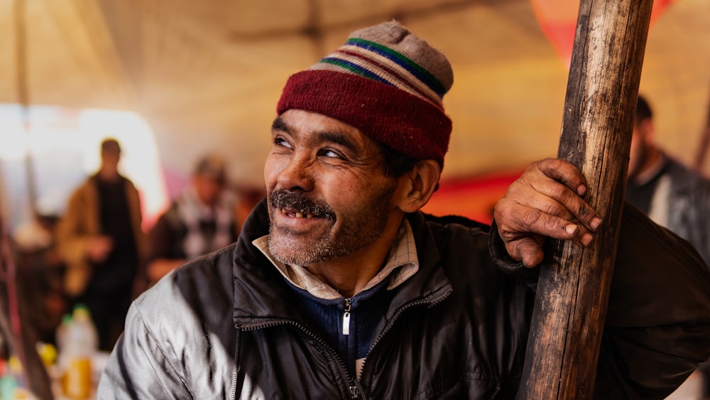 Hombre con chaqueta de cuero negro con gorro de punto rojo y blanco