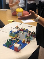 A cozy family moment with everyone gathered around the table building LEGO sets together.