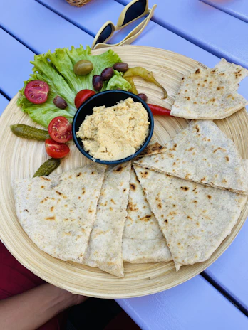 Close-up of a colorful mezze platter featuring hummus, olives, and fresh pita bread.