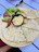 A colorful meze platter featuring hummus, olives, grilled vegetables, and warm bread on a rustic wooden table.