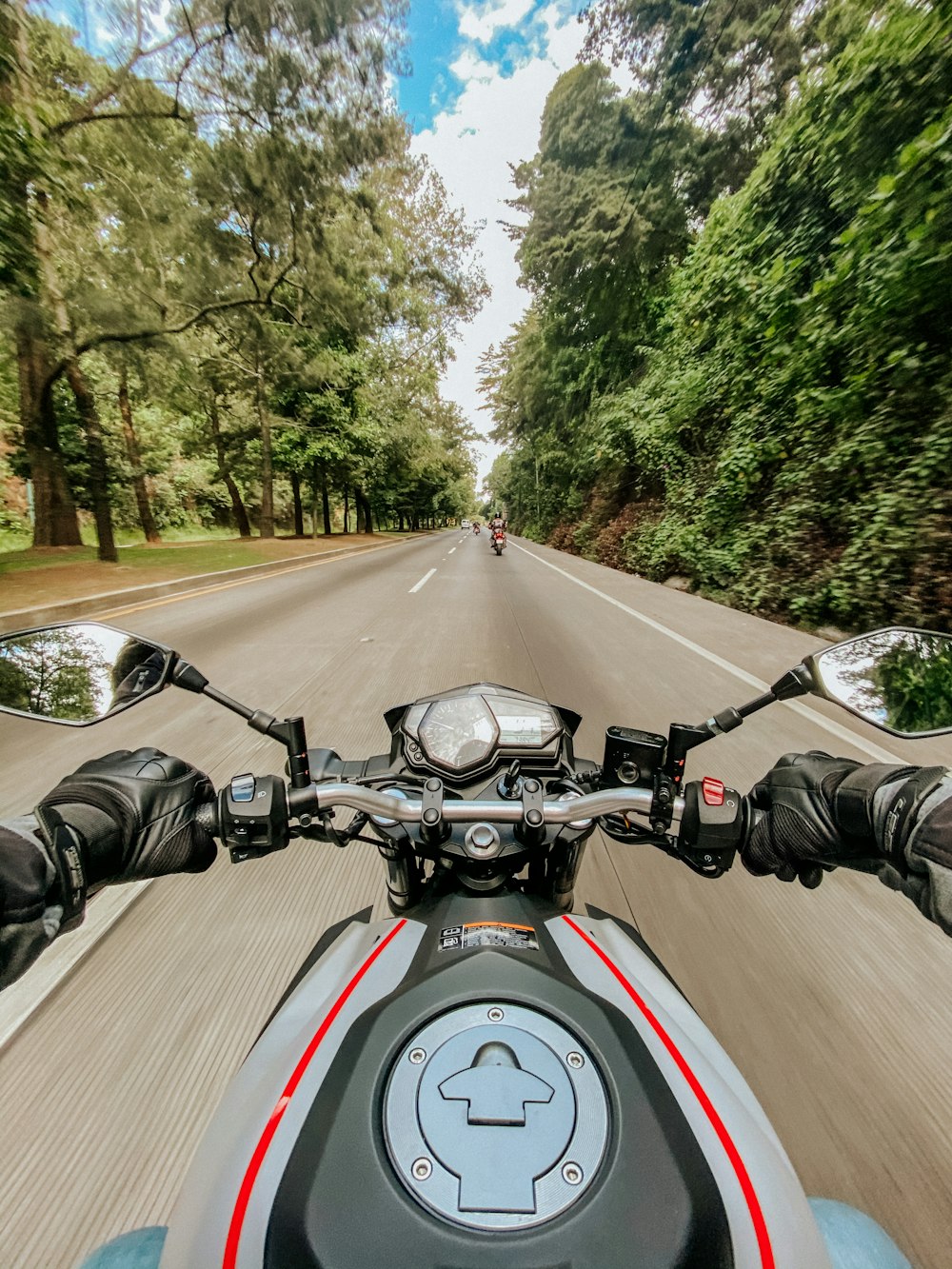 Hombre que monta motocicleta en la carretera durante el día