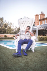 woman in white and black floral dress sitting on white and blue outdoor pool during daytime