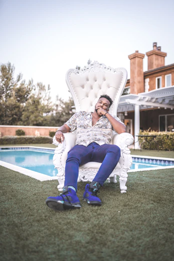woman in white and black floral dress sitting on white and blue outdoor pool during daytime