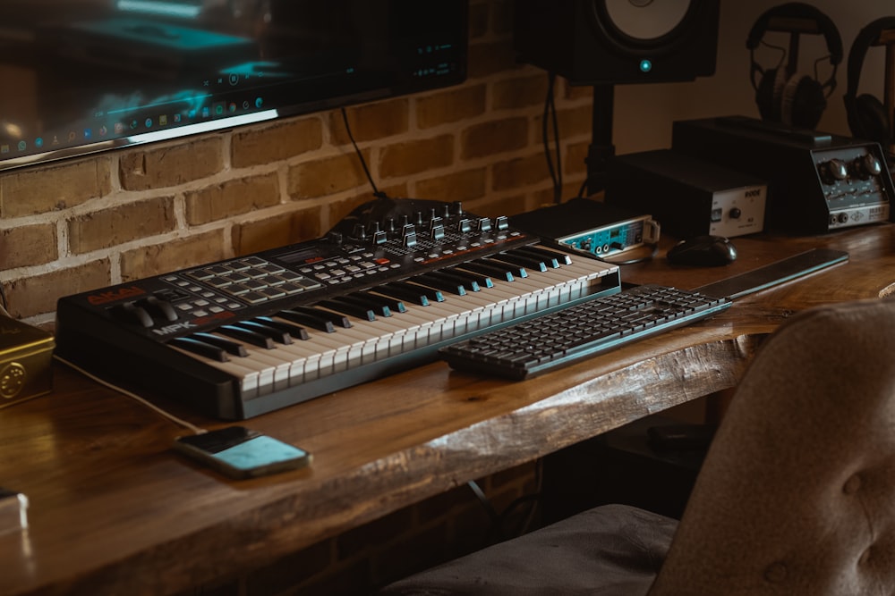 teclado de computador preto e branco na mesa de madeira marrom