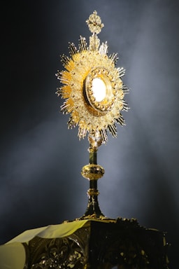 A glowing golden symbol of gnosis against a dark purple cosmic background.