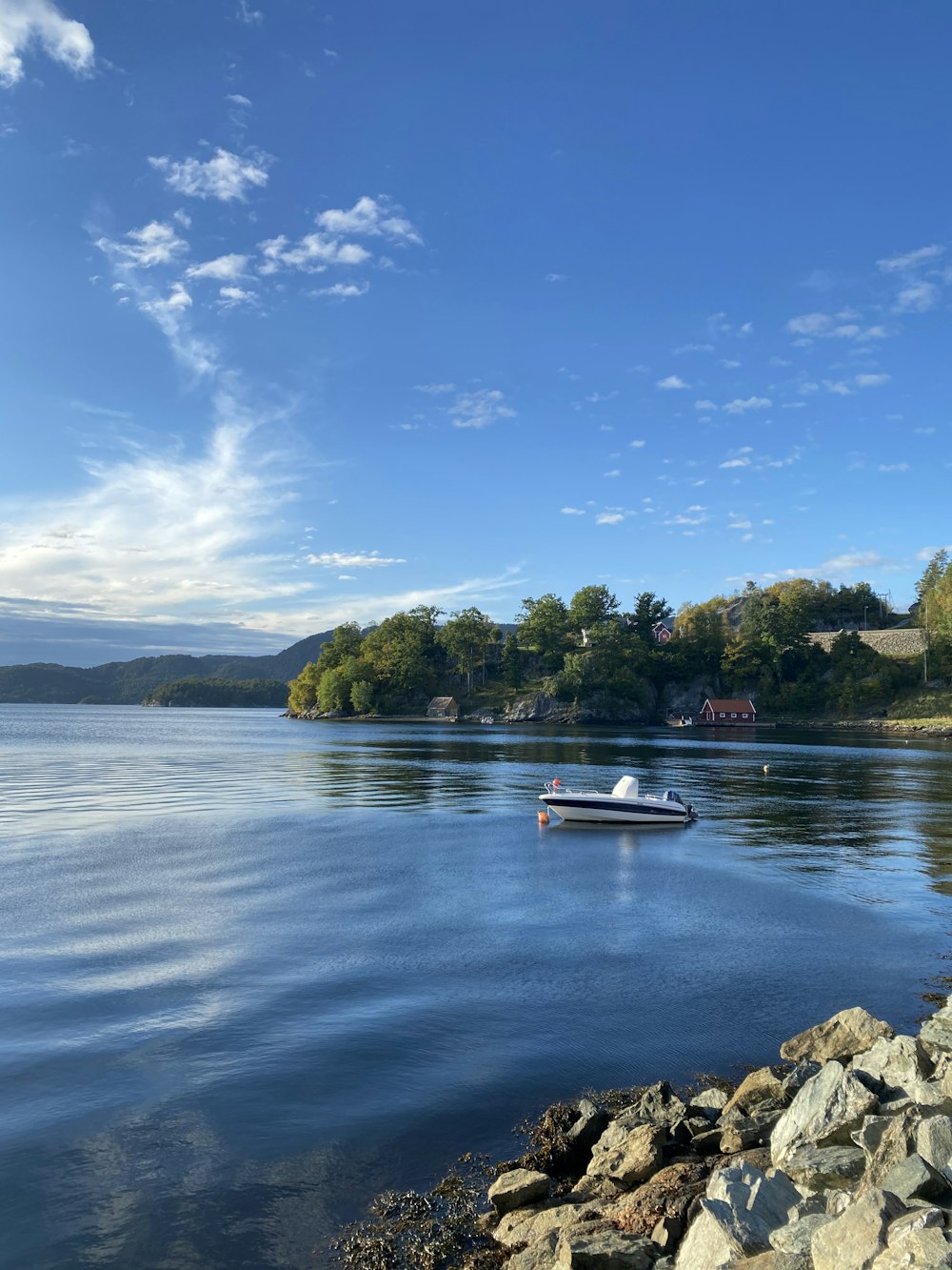 white and blue boat on lake during daytime