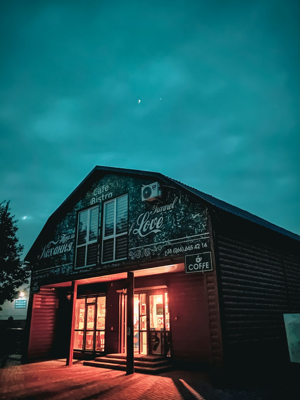 red and black wooden building under gray sky