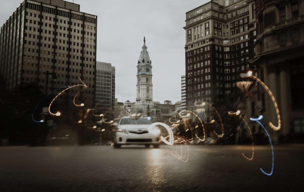 white car on road near high rise buildings during daytime