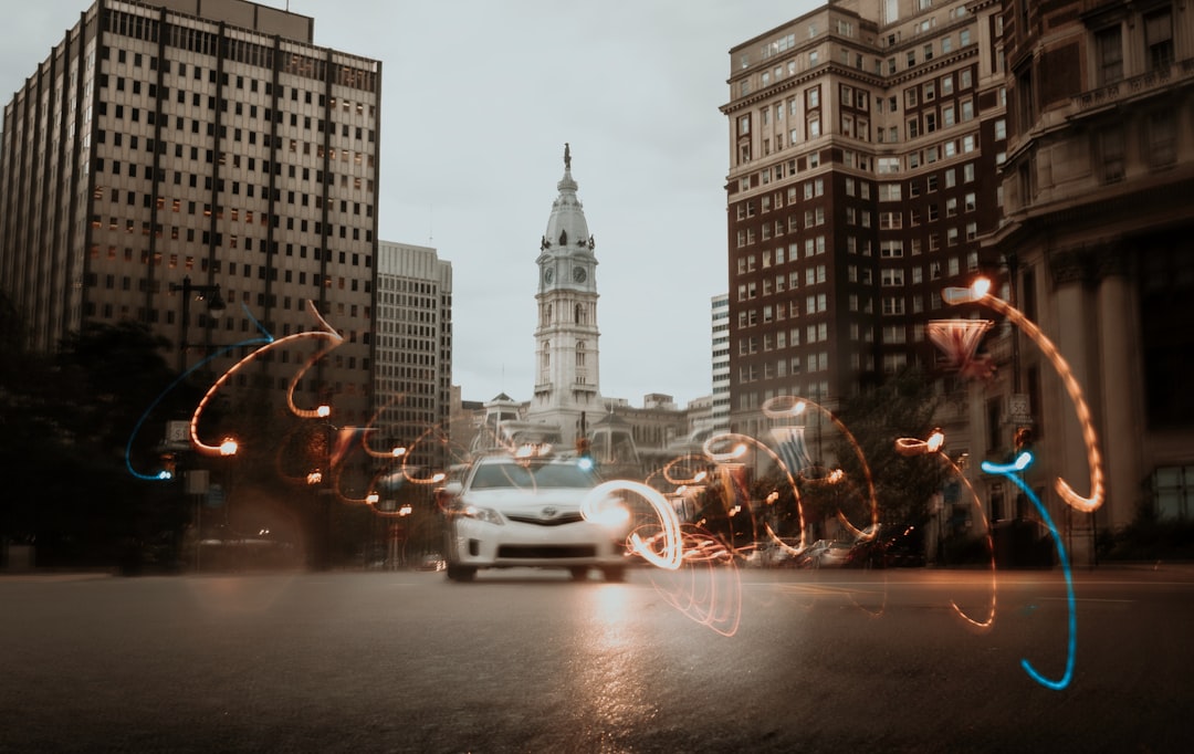 white car on road near high rise buildings during daytime