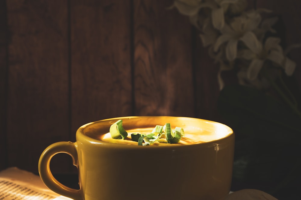 yellow ceramic mug with green leaves