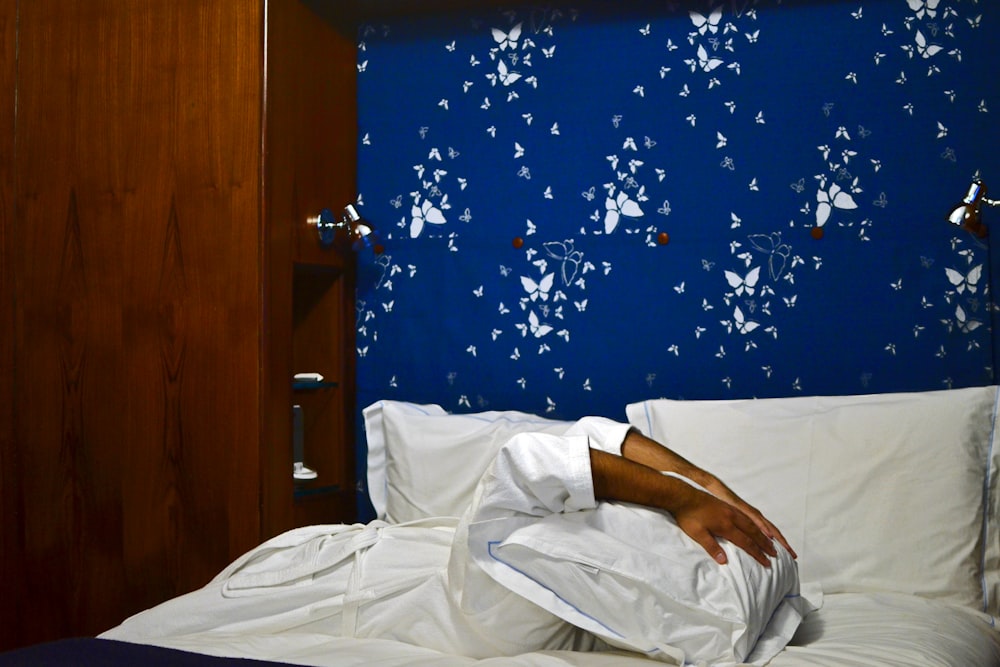 man in white button up shirt lying on bed