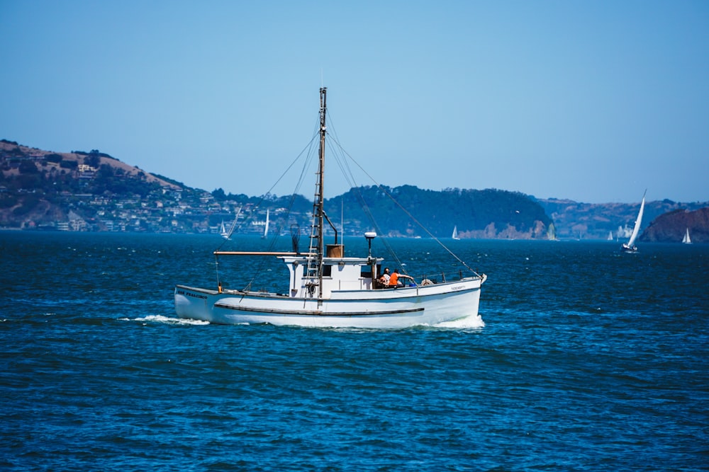 white and blue boat on sea during daytime