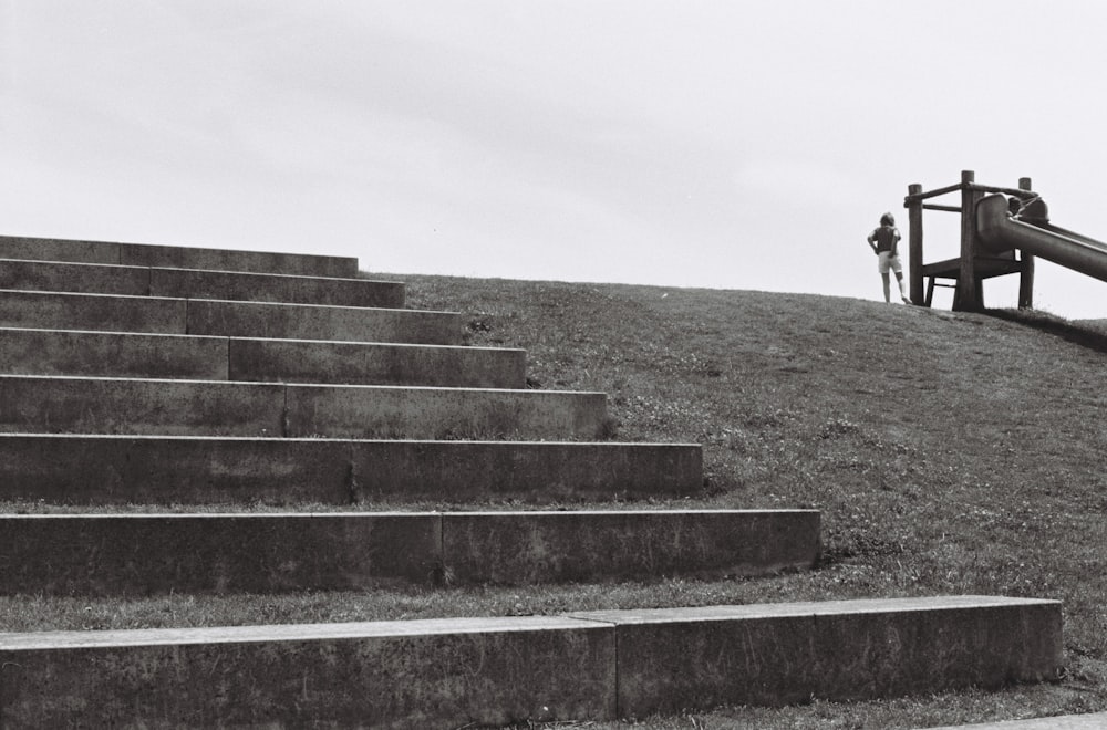 person in black jacket walking on gray concrete stairs during daytime