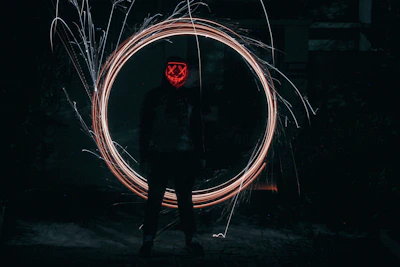 A mysterious figure in a gold-accented mask standing under a flickering streetlamp.