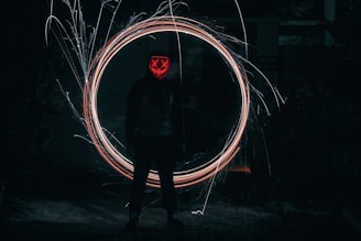 A mysterious anime character cloaked in shadows with glowing eyes.