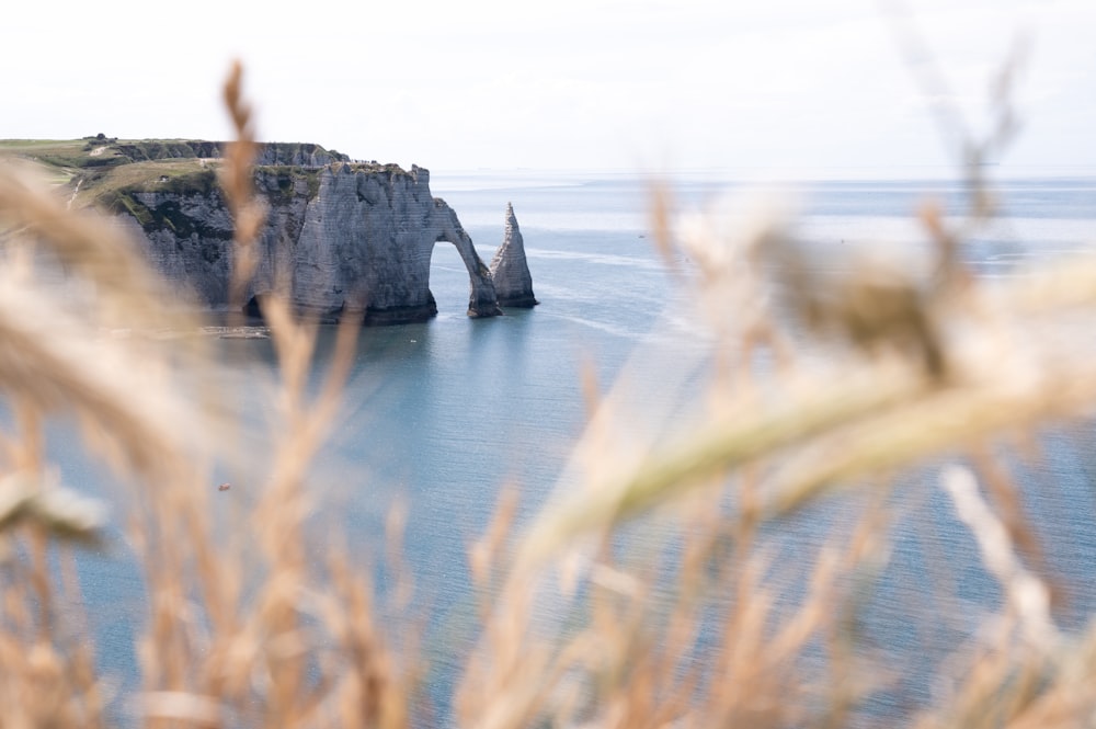 black rock formation on body of water during daytime