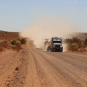 brown truck on dirt road during daytime